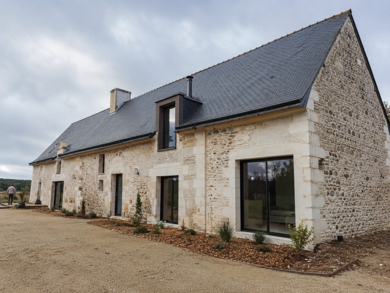 Longère rénovée avec murs en pierre claire et toiture en ardoise