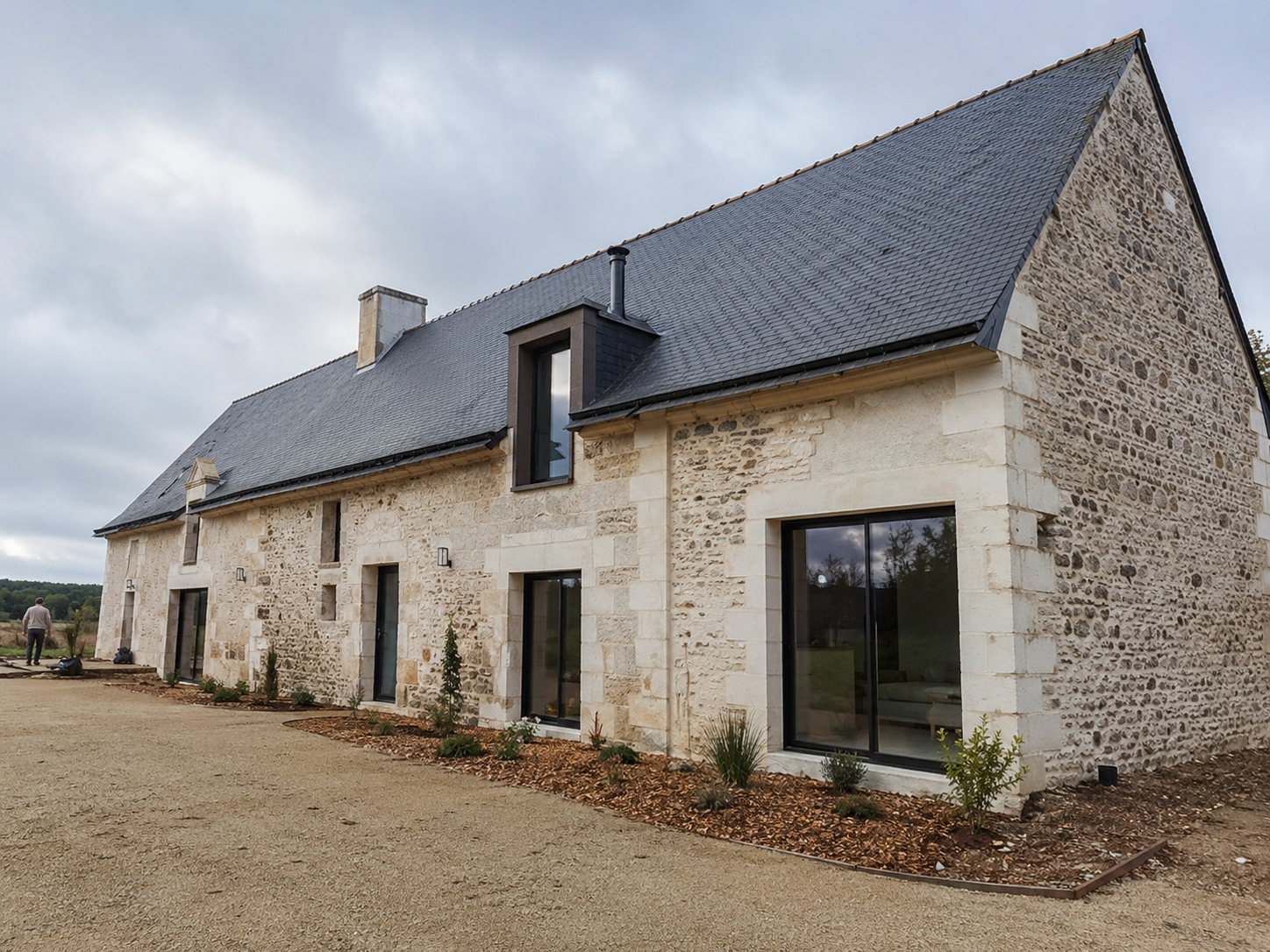 Longère rénovée avec murs en pierre claire et toiture en ardoise